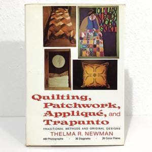 May include: A book titled "Quilting, Patchwork, Appliqué, and Trapunto" by Thelma R. Newman. The cover features images of quilts, a patchwork skirt, and a decorative pillow. The book includes 400 photographs, 30 diagrams, and 26 color plates.