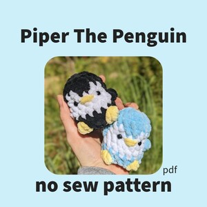 May include: Two crocheted penguin toys, one black and white and one blue and white, are held in a hand. The toys are small and have a no-sew pattern. The text "Piper The Penguin no sew pattern pdf" is at the bottom of the image.