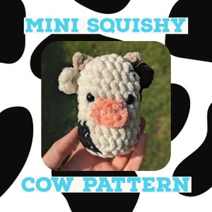 May include: A white and black crocheted cow plush toy with a pink nose. The toy is labeled "Mini Squishy Cow Pattern".