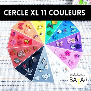 Könnte beinhalten: Ein bunter Kreis, der in 11 Abschnitte unterteilt ist, jeder mit einer anderen Farbe. Jeder Abschnitt enthält eine Vielzahl von Holzknöpfen mit verschiedenen Designs, darunter Tiere, Blumen und geometrische Formen. Der Text "CERCLE XL 11 COULEURS" befindet sich oben auf dem Kreis.