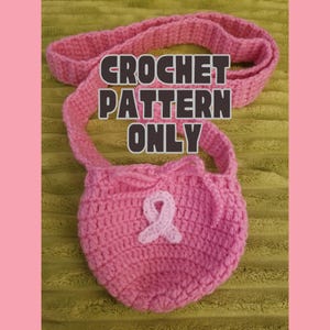 Könnte beinhalten: Eine rosa gehäkelte Tasche mit Trageriemen, mit einem weißen Band und dem Text "CROCHET PATTERN ONLY". Die Tasche ist aus weichem, strukturiertem Garn gefertigt und hat einen Kordelzugverschluss. Der Hintergrund ist ein strukturiertes grünes Gewebe.