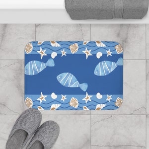 May include: Blue bath mat with a nautical theme featuring white fish, brown seashells, and starfish on a blue background.