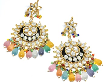 May include: A pair of gold-toned earrings with a floral design and a black crescent moon shape. The earrings feature clear, reflective stones and colorful teardrop-shaped beads in various colors, including pink, yellow, and blue.