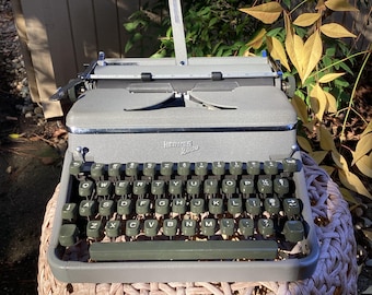 Máquina de escribir portátil vintage Hermes 2000 con manual de funcionamiento, estuche, manual de usuario y pinceles.