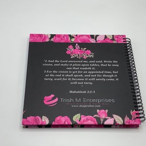 Peut inclure: Un carnet &agrave; spirales noir et rose avec un motif floral et une citation de la Bible, Habacuc 2:2-3. La citation dit : "2 Et l'&Eacute;ternel me r&eacute;pondit, et dit : &Eacute;cris la vision, et grave-la sur des tables, afin que celui qui la lit la lise couramment. 3 Car la vision est encore pour un temps d&eacute;termin&eacute;, mais &agrave; la fin elle se r&eacute;alisera, et elle ne mentira pas : si elle tarde, attends-la, car elle viendra certainement, elle ne tardera pas." Le carnet porte &eacute;galement le texte "Trish M Enterprises Where Dreams & Faith Meet www.shoptrishm.com".