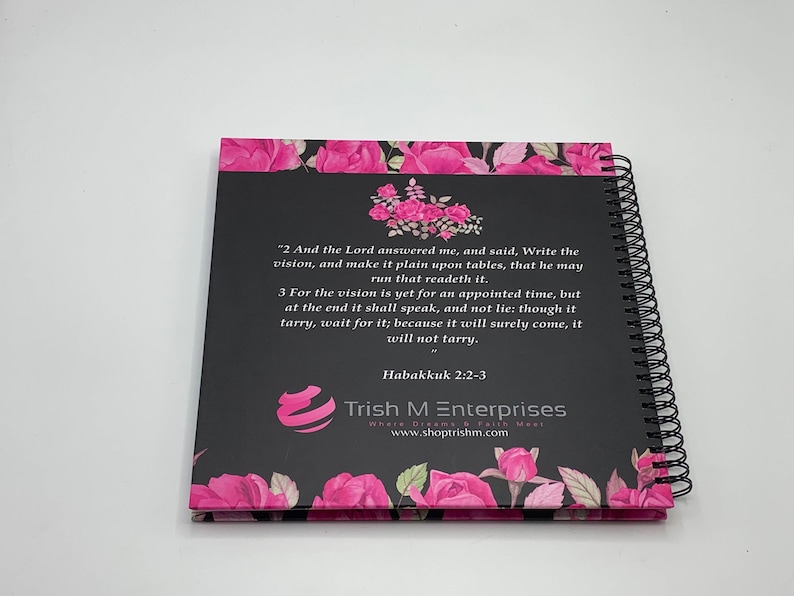 Peut inclure: Un carnet &agrave; spirales noir et rose avec un motif floral et une citation de la Bible, Habacuc 2:2-3. La citation dit : "2 Et l'&Eacute;ternel me r&eacute;pondit, et dit : &Eacute;cris la vision, et grave-la sur des tables, afin que celui qui la lit la lise couramment. 3 Car la vision est encore pour un temps d&eacute;termin&eacute;, mais &agrave; la fin elle se r&eacute;alisera, et elle ne mentira pas : si elle tarde, attends-la, car elle viendra certainement, elle ne tardera pas." Le carnet porte &eacute;galement le texte "Trish M Enterprises Where Dreams & Faith Meet www.shoptrishm.com".