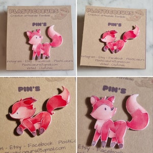 Peut inclure: Une épingle en forme de renard rouge avec un ventre blanc et un nez rose. L'épingle est sur un fond brun avec le texte "Plasticoeurs Création artisanale familiale PIN'S" et des informations sur les réseaux sociaux.