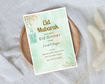 May include: A green and gold Eid Mubarak invitation with a lantern design. The invitation includes the text "Eid Mubarak", "You Are Invited To", "Eid Dinner", "Hosted By", "Javed & Nafisa", "xxx Place", "Wednesday April 10th - Begins At 5.30 pm", "12345 Street Address, City State", and "Rsvp To XXXX At 123.456.7891".