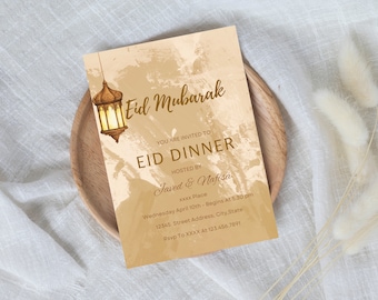Könnte beinhalten: Eine goldene und braune Einladungskarte mit einem dekorativen Laternen-Design. Der Text lautet "Eid Mubarak" und enthält Details für ein Eid-Dinner, das von Javed & Nafisa ausgerichtet wird. Die Einladung enthält Datum, Uhrzeit, Ort und RSVP-Informationen.