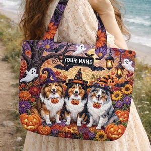 May include: A rectangular tote bag featuring a colorful Halloween-themed illustration of three Sheltie dogs wearing witch hats and pumpkin collars. The design includes ghosts, lanterns, and sunflowers with a black label reading YOUR NAME.