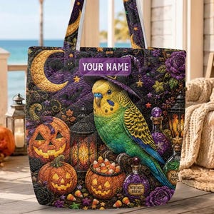 May include: A quilted tote bag featuring a green and yellow budgie wearing a witch hat, surrounded by jack-o'-lanterns, lanterns, purple roses, and a crescent moon. The bag includes a rectangular label with the text YOUR NAME printed on it.
