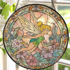 May include: Round stained glass window featuring a fairy in a green dress and yellow hair, surrounded by flowers. The artwork has a black border and is suspended by a chain. The color palette includes pink, green, yellow, and orange.