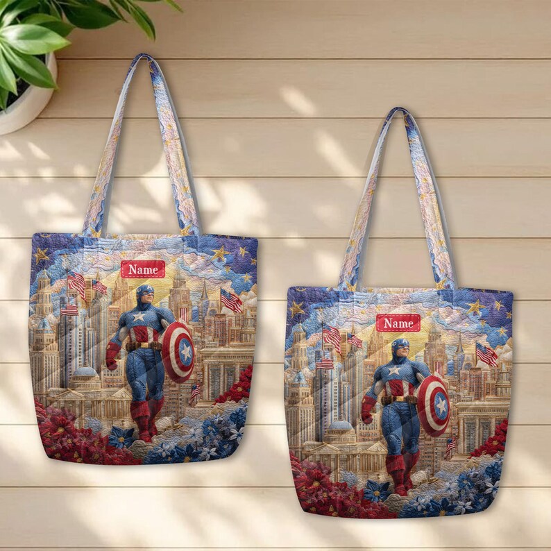 May include: Two quilted tote bags featuring a graphic of Captain America standing in front of a city skyline with American flags, stars, and floral accents. Each bag includes a rectangular red label with the word Name printed in white text.