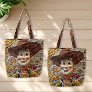 May include: Two quilted tote bags featuring a printed graphic of a cowboy character wearing a brown hat and yellow shirt. The design includes gold star accents on a textured background and a rectangular label with the word Name printed on it.
