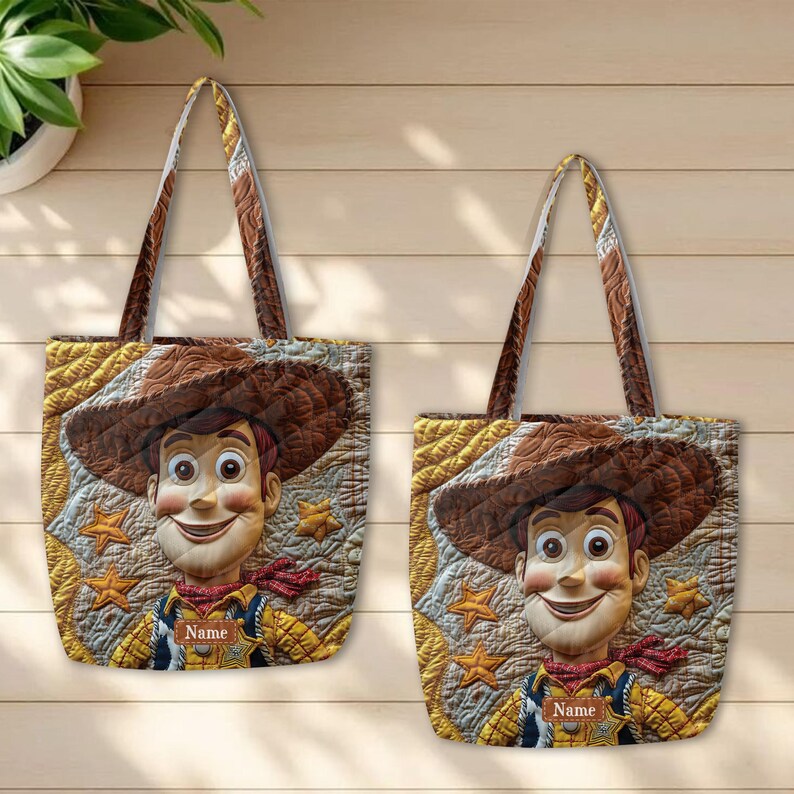 May include: Two quilted tote bags featuring a printed graphic of a cowboy character wearing a brown hat and yellow shirt. The design includes gold star accents on a textured background and a rectangular label with the word Name printed on it.