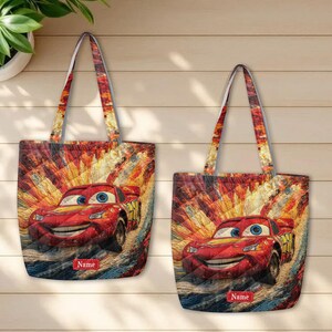 May include: Two quilted tote bags featuring a red race car character with blue eyes and a yellow number 95 on the side. The background shows a colorful, abstract motion blur effect. Each bag includes a rectangular red label with the text Name.