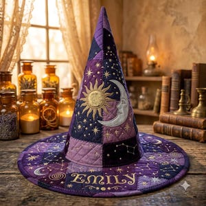 Puede incluir: Un sombrero de bruja acolchado en tonos morados y azul oscuro, con motivos bordados de sol dorado y luna plateada, patrones de estrellas y constelaciones. El ala muestra el nombre Emily en bordado dorado con textura de rombos.
