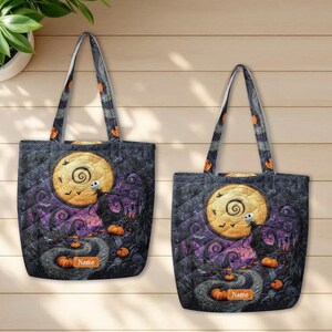 May include: Two quilted tote bags featuring a dark, whimsical scene with a large yellow moon, a skeletal figure, and orange pumpkins. The design includes a rectangular orange label with the text Name on each bag, set against a dark purple and black background.