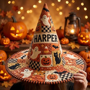 May include: A quilted witch hat featuring a patchwork design with orange, black, and white colors. The hat displays the name HARPER in black letters, surrounded by appliqued motifs of ghosts, pumpkins, black cats, bats, and candy corn.