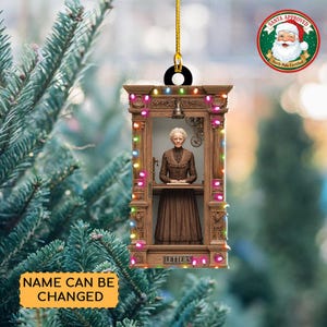 May include: A Christmas ornament featuring a brown wooden structure with a woman inside, adorned with colorful lights. The ornament has a gold string for hanging and a Santa Approved seal. The text "LETTERS" is visible at the bottom, and "NAME CAN BE CHANGED" is on a yellow banner.