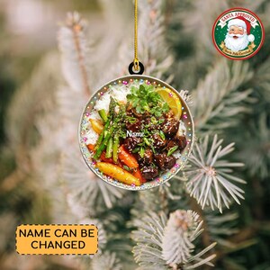 May include: A round Christmas ornament featuring a colorful image of a meal with rice, vegetables, and meat. The ornament has a gold string for hanging and the text "Name" is visible. The ornament also has the text "Name Can Be Changed". A Santa Approved logo is in the upper right corner.
