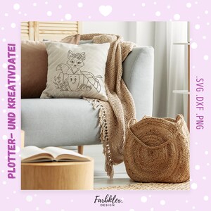 May include: A decorative pillow with a fox and pumpkin design sits on a gray sofa, next to a woven basket and a tan throw blanket. The pillow features a fox wearing a floral crown and a pumpkin with a smiling face. The text "PLOTTER- UND KREATIVDATEI" is visible.