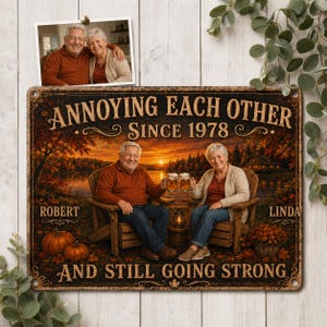 May include: A rectangular metal sign featuring a sunset lake scene with a couple sitting in wooden chairs holding beer mugs. The text reads: ANNOYING EACH OTHER SINCE 1978, ROBERT, LINDA, AND STILL GOING STRONG. A photo of the couple is pinned above.