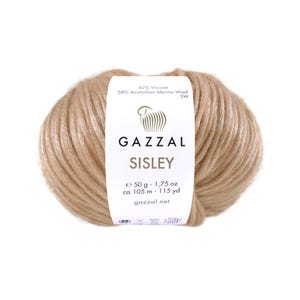 Puede incluir: Ovillo de lana marrón claro con una etiqueta "GAZZAL SISLEY". La etiqueta también indica que la lana es 42% viscosa y 58% lana merino australiana. El ovillo contiene 50 g de hilo, aproximadamente 105 m.