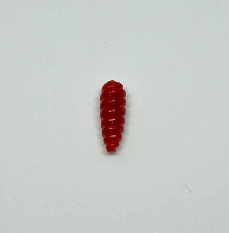 Puede incluir: Un se&ntilde;uelo de pesca de pl&aacute;stico rojo con forma de gusano.