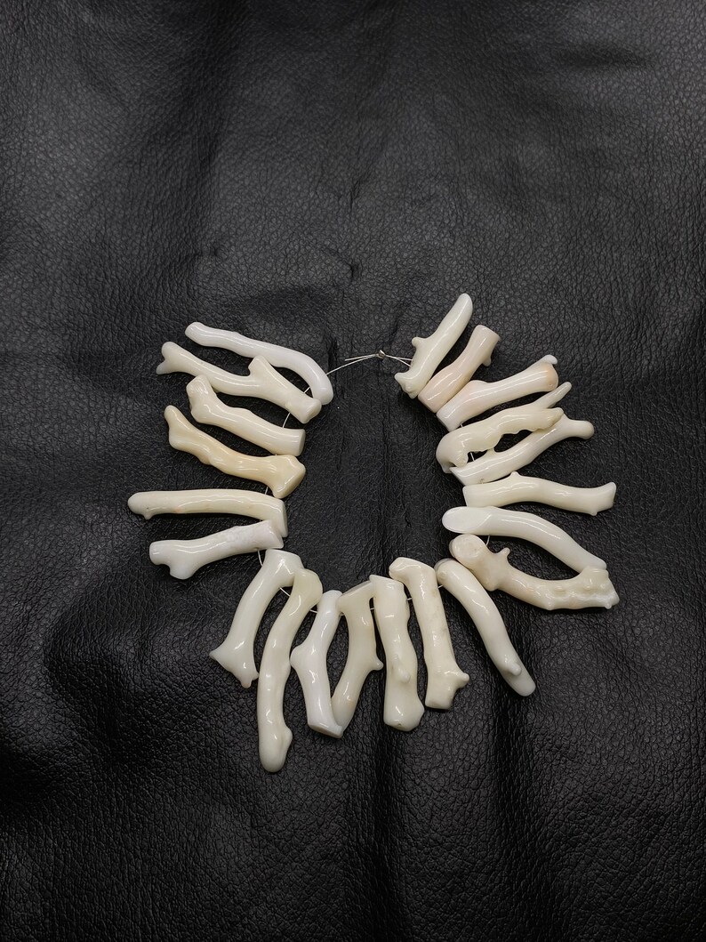 Op de afbeelding: Een witte koraaltak ketting met een draadlus sluiting. De ketting is gemaakt van natuurlijke koraaltakken en is een mooi en uniek sieraad.