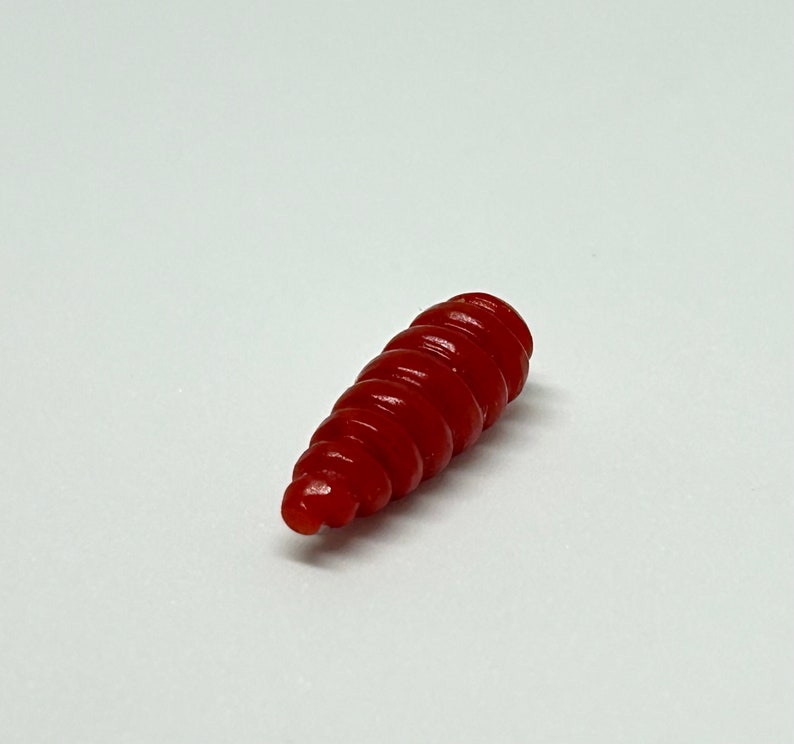 Puede incluir: Un se&ntilde;uelo de pesca rojo en forma de espiral.