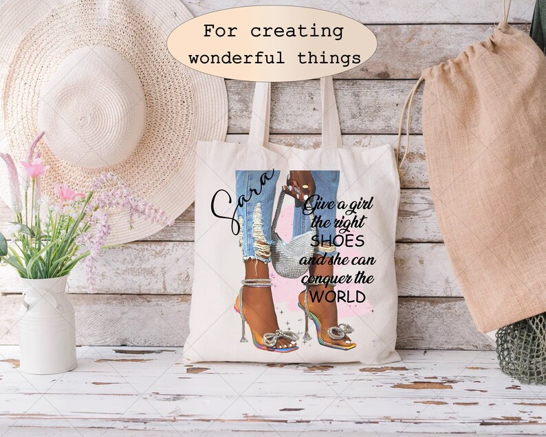 Może przedstawiać: Biała torba typu tote z nadrukiem kobiety w niebieskich dżinsach i szpilkach. Tekst na torbie brzmi "Sara Give a girl the right SHOES and she can conquer the WORLD".