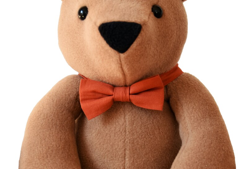 Plush memory bear with bow tie in terracota color on his neck