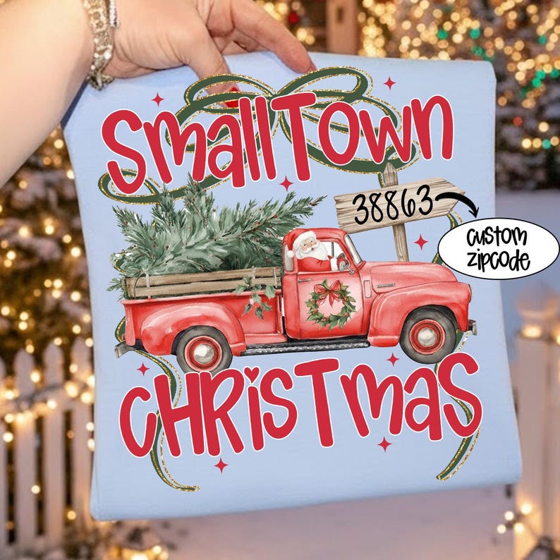 May include: Light blue Christmas-themed graphic featuring a red vintage pickup truck carrying a Christmas tree, Santa Claus, and the words "Small Town Christmas." Includes a sign with a zip code and the text "custom zipcode."