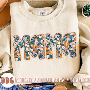 May include: A beige sweatshirt with the word "Mama" in large, colorful letters. The letters are covered in a floral pattern with orange, blue, and purple flowers. The text "300 DPI COMMERCIAL USE PNG SUBLIMATION" is at the bottom of the image.