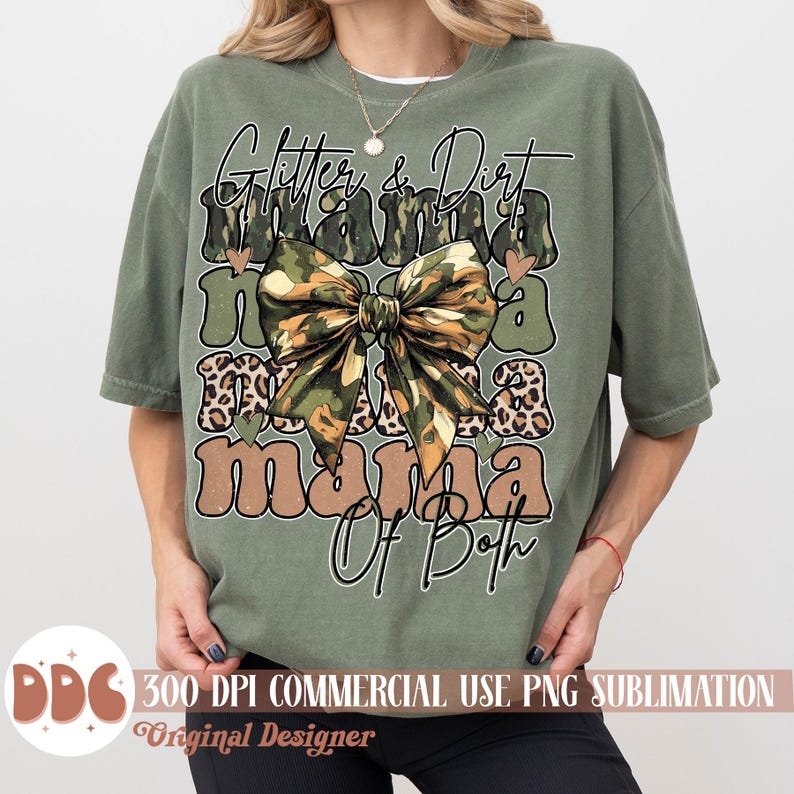 以下が含まれることがあります： 緑色のTシャツに、茶色と白の文字で「Glitter & Dirt Mama Of Both」と書かれています。文字の周りは迷彩柄と茶色のリボンで囲まれています。