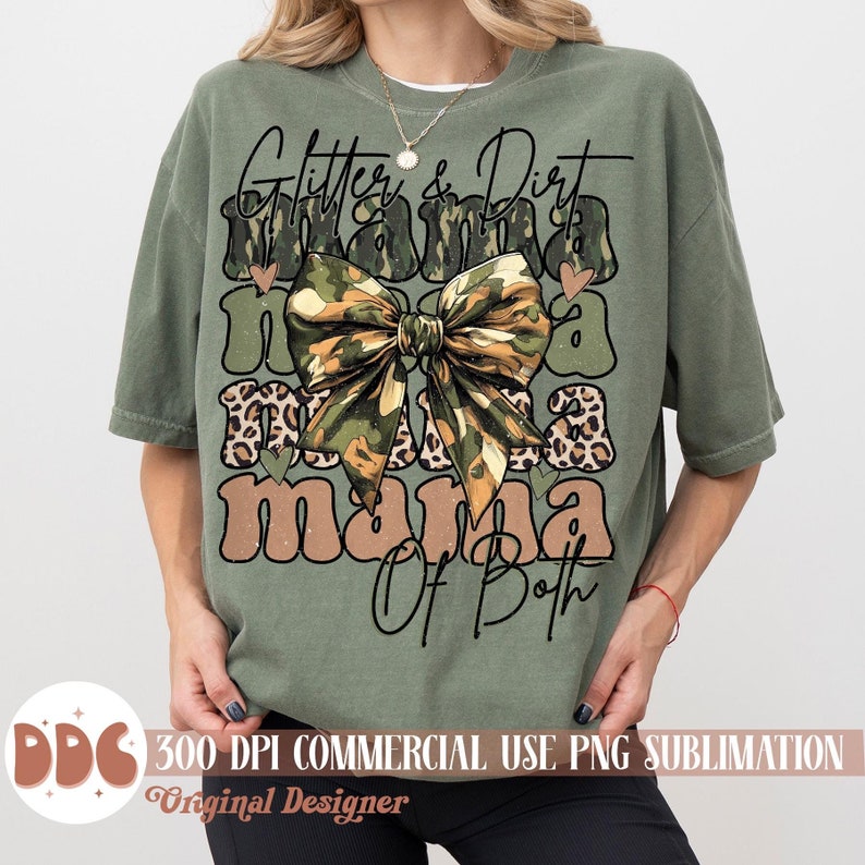 以下が含まれることがあります： 緑色のTシャツに、茶色と黒のフォントで「Glitter & Dirt Mama Of Both」という文字が書かれています。文字は迷彩柄のリボンとヒョウ柄のアクセントで飾られています。