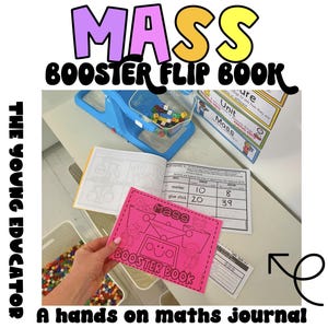 Op de afbeelding: Een roze en zwart "Mass Booster Book" met een cartoonmonster op de omslag. Het boek is open op een pagina met een tabel die items en hun massa in grammen weergeeft. Het boek ligt op een tafel met een blauwe weegschaal en andere educatieve materialen.