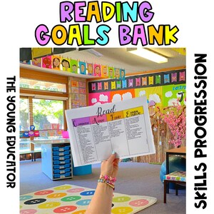Könnte beinhalten: Ein Klassenzimmer mit einer farbenfrohen Wanddekoration mit den Worten "Reading Goals Bank". Eine Person hält ein weißes Blatt Papier mit dem Wort "Read" in schwarzem Stift geschrieben. Das Papier ist in vier Spalten mit den Überschriften: Comprehension, Accuracy, Fluency und Expanding Vocabulary unterteilt.