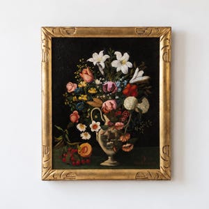 Peut inclure: Une peinture à l'huile dans un cadre doré orné représentant un arrangement floral dans un vase clair. Le bouquet comprend des lys blancs, des tulipes roses et rouges, et de petites fleurs jaunes sur un fond sombre. Des baies rouges et une pêche sont posées à côté.