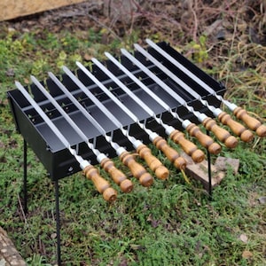 Portable BBQ grill for 6–12 skewers. Foldable, fire-resistant, made of 2mm steel. Skewers optional. Perfect for camping & picnics