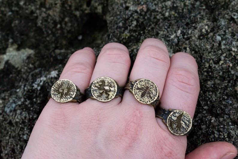 May include: Four silver rings with different designs. The rings feature a lion, a bird, a bee, and a wolf.