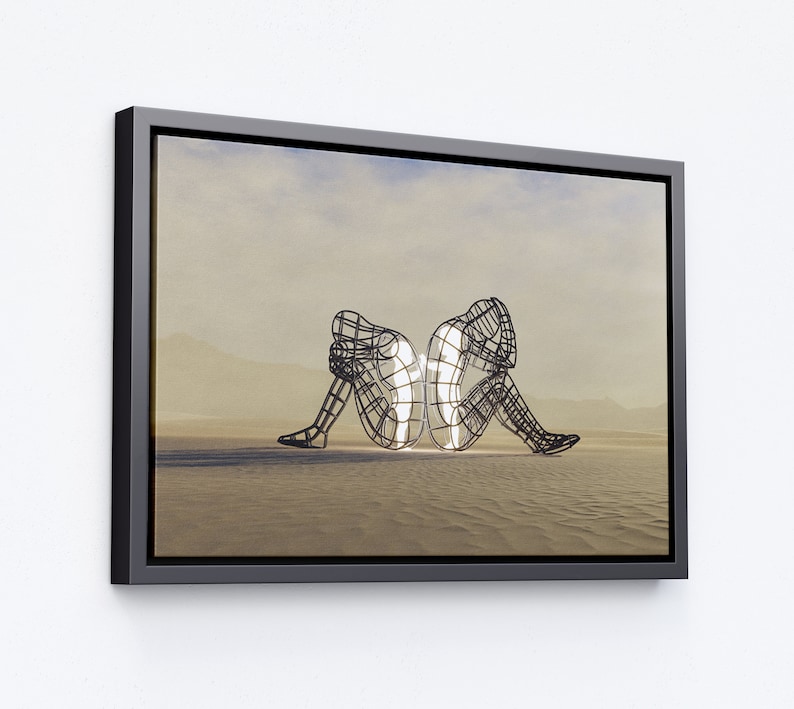 May include: A black framed canvas print of a contemporary art sculpture. Two figures are made of wire and are facing each other. The figures are in a desert landscape.