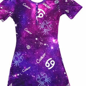 May include: Purple onesie with a galaxy print featuring the Cancer zodiac sign and the word "Cancer" repeated throughout the design.