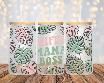 May include: Three clear glass tumblers with bamboo lids and straws. The tumblers have a white background with a pattern of pink and green monstera leaves. The middle tumbler has the text "WIFEY MAMA BOSS" in pink and green letters.
