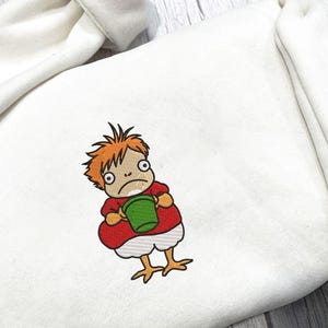 May include: White sweatshirt with an embroidered cartoon character. The character has orange hair, a red shirt, and is holding a green bucket. The character's legs are yellow and resemble chicken feet. The sweatshirt is made of a soft, comfortable material.