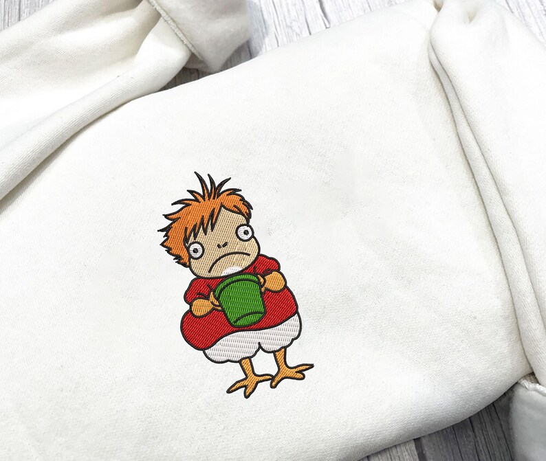 May include: White sweatshirt with an embroidered cartoon character. The character has orange hair, a red shirt, and is holding a green bucket. The character's legs are yellow and resemble chicken feet. The sweatshirt is made of a soft, comfortable material.