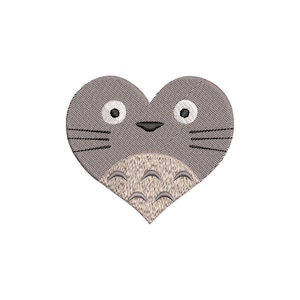 May include: A gray heart-shaped embroidery design featuring a cartoon character face. The design includes black whiskers, a black nose, and white eyes with black pupils. The lower portion has a textured, light brown belly.