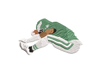 May include: An embroidered patch featuring a football player in a green uniform with white and black accents, holding a brown football. The player is in a diving position, with the ball tucked against their body.