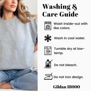 May include: A gray sweatshirt with a washing and care guide. The guide includes instructions to wash inside-out with like colors, wash in cool water, tumble dry at low-temp, do not bleach, and do not iron design. The brand is Gildan 18000.